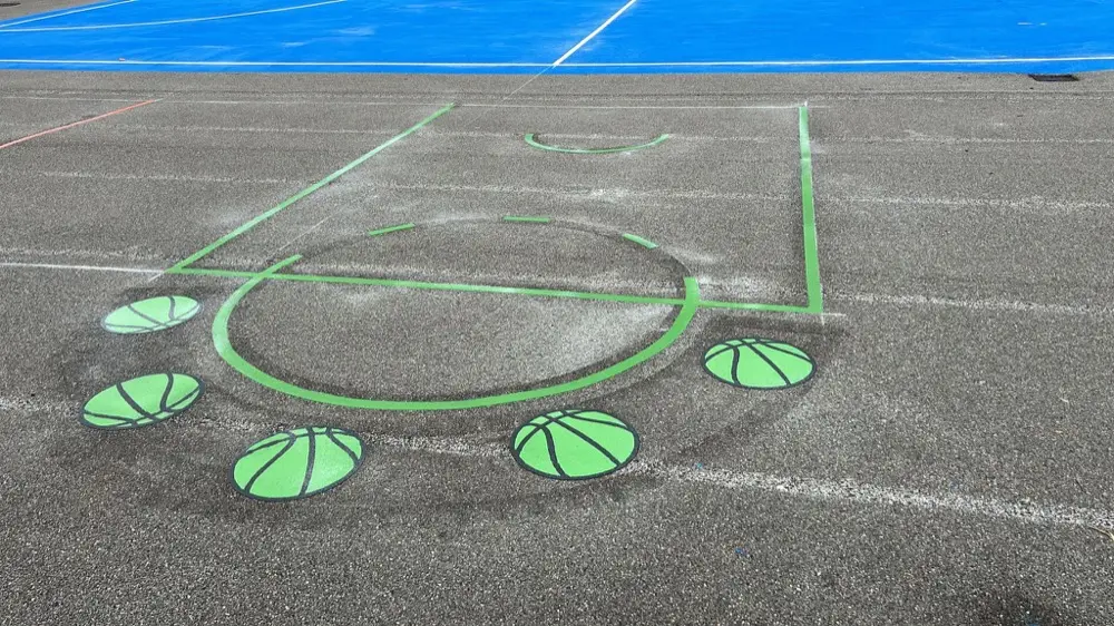 Basketball court thermoplastic markings on a school playground