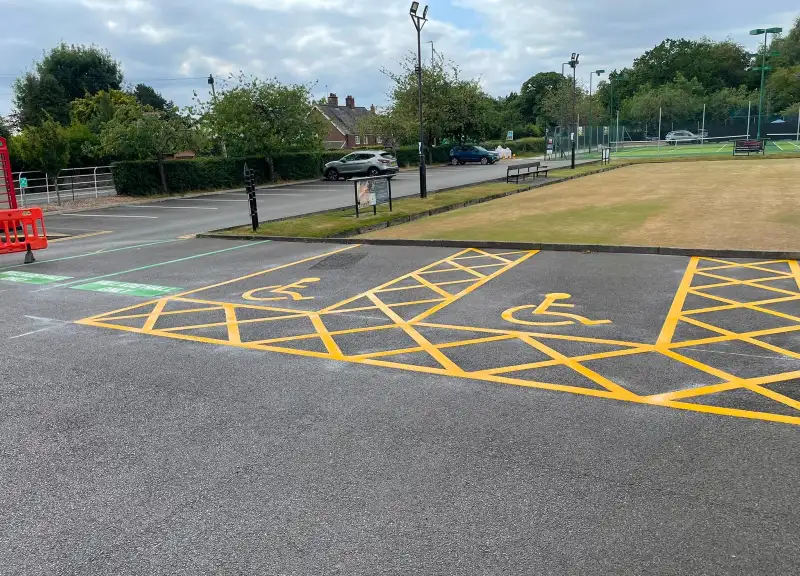 Thermoplastic road-safety and car park markings being installed