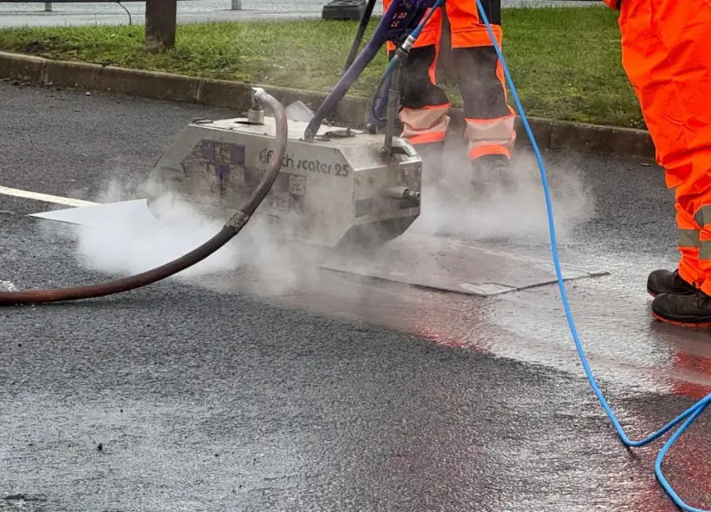 Old thermoplastic playground markings being removed from a surface