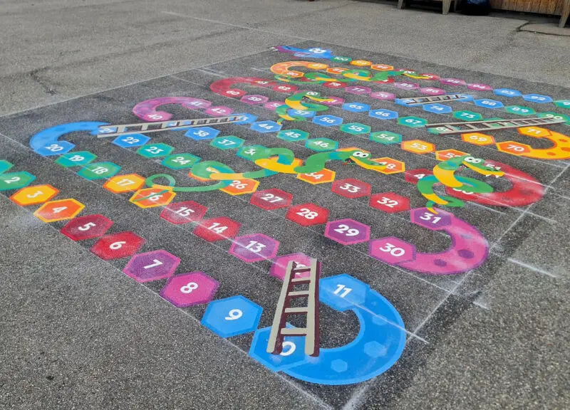 The Uniplay team laying thermoplastic playground markings on site